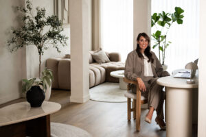 Vrouw met laptop aan een tafel in een lichte werkruimte, bij het artikel over een contentstrategie die je volhoudt